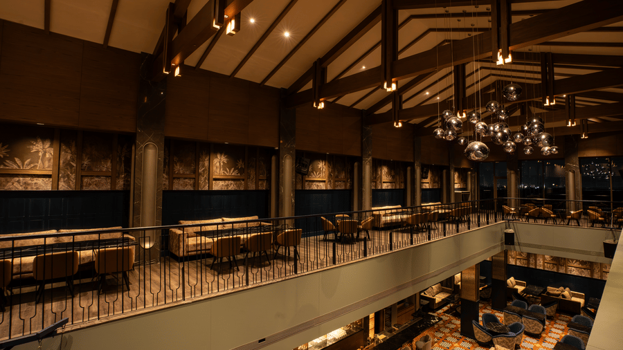 Two-floor bar interior with railings, seating, and lights at Origyn, Merlis Hotel, Coimbatore.