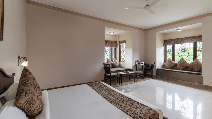 A bright bedroom at Mewar Mansion Villa By Amantra, Udaipur with a double bed and adjacent seating area.