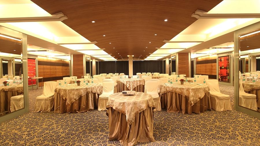 Image of Amber hall at Mirage featuring a stylish decor with brown round tables and chairs | Mirage Hotel