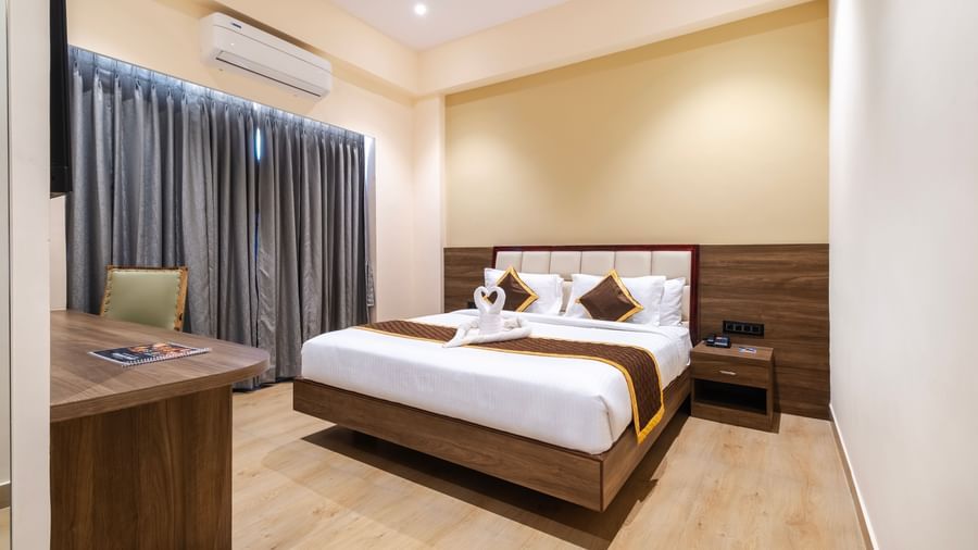 Spacious room at Monday Hotels Amalapuram Heights with elegant interiors and air-conditioning.