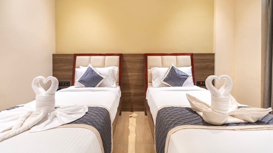 Guest twin room at Monday Hotels Amalapuram Heights with swan towel decor.