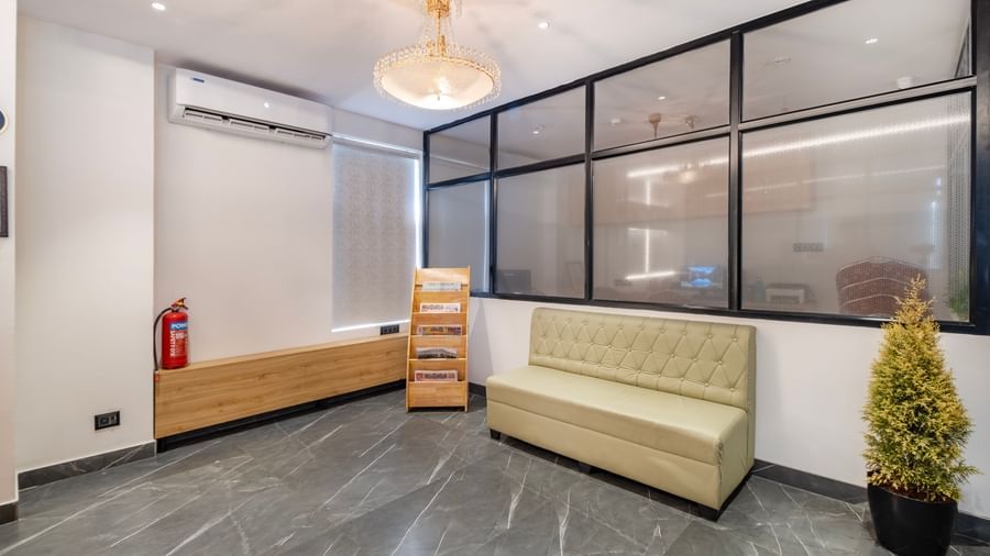 Lobby seating area with glass partitions and plant decor at Monday Hotels Amalapuram Heights