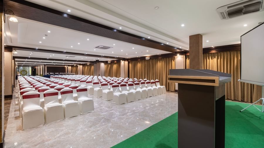 Conference hall at Monday Hotels Amalapuram Heights set with podium and theatre style seating.