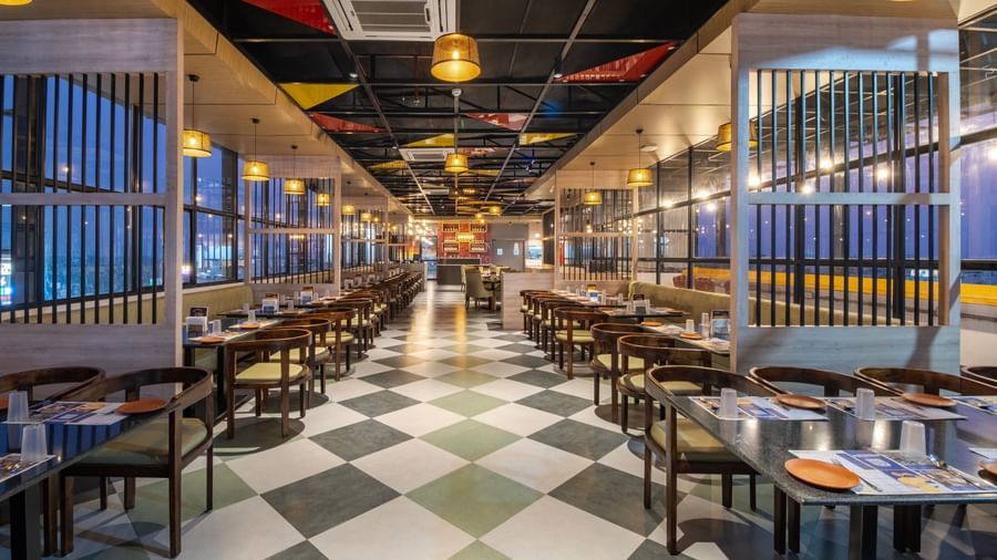 Spacious restaurant at Monday Hotels Amalapuram Heights with modern interiors and a city view.