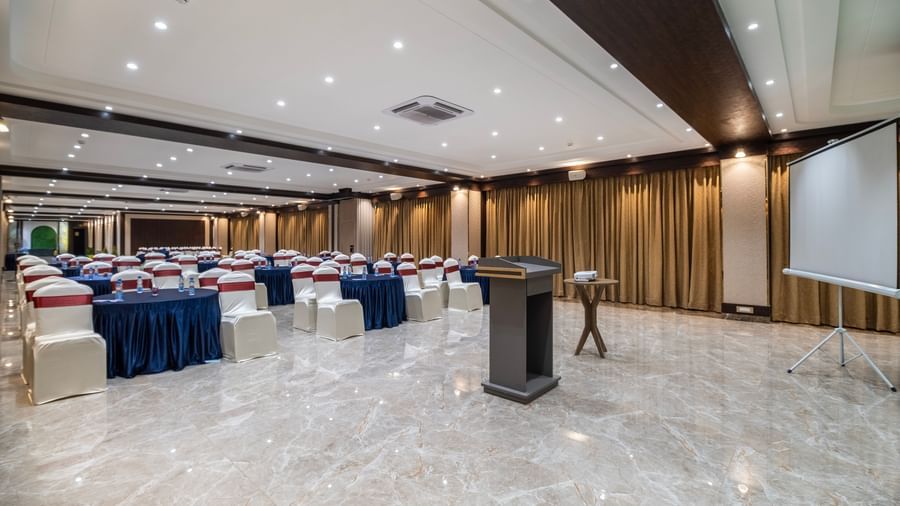 Event hall at Monday Hotels Amalapuram Heights arranged with cluster style seating and stage podium.