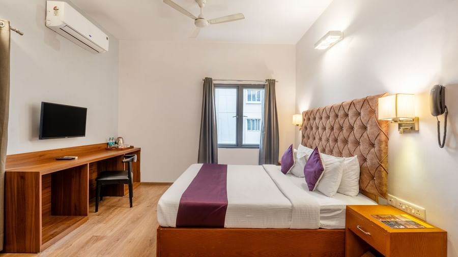 A hotel room with a bed, wall mounted tv, and air conditioning – Monday Hotels HITEC City, Hyderabad