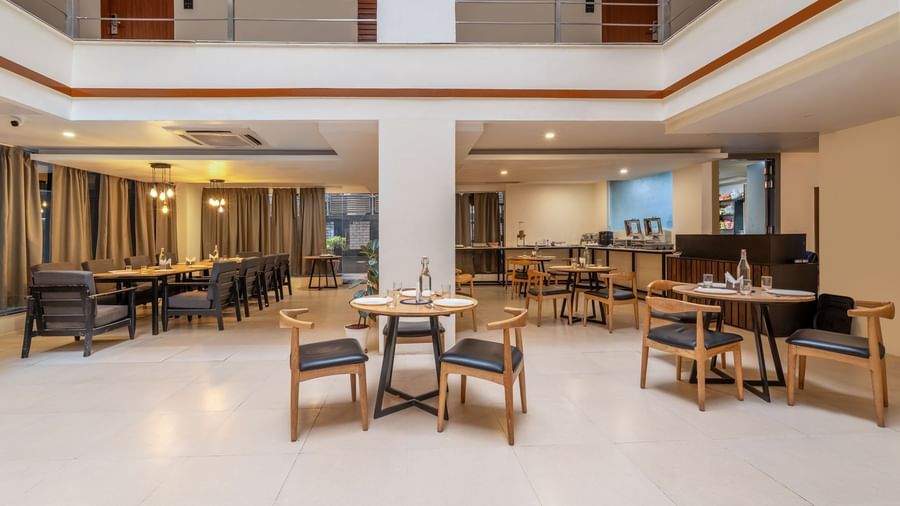 A spacious dining hall with tables and chairs neatly arranged with bright lighting - Monday Hotels HITEC City, Hyderabad