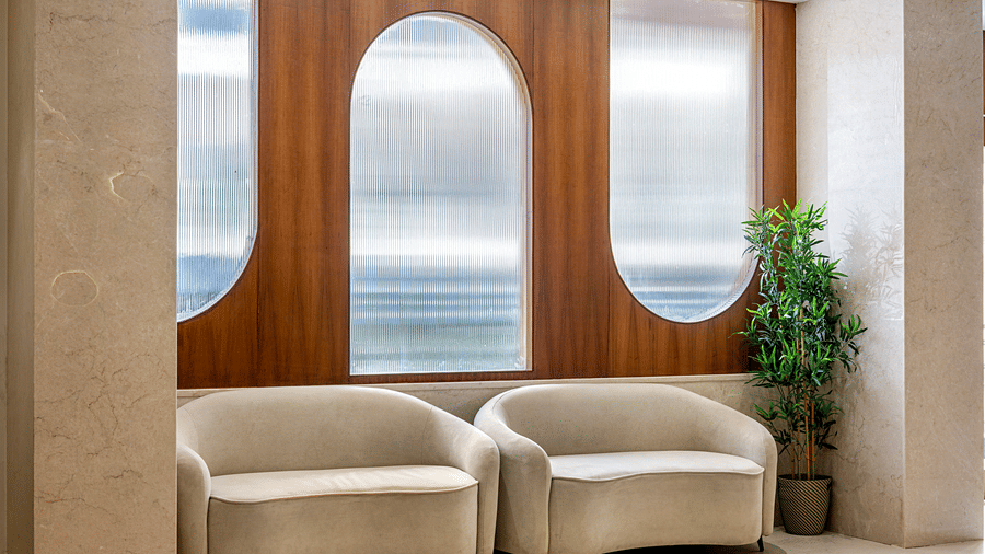 The reception at Monday Premium, Madhapur, featuring cushions, a plant, and windows.