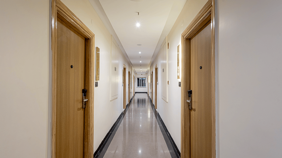 The lobby at Monday Premium, Madhapur, featuring an elongated hallway with several doors.