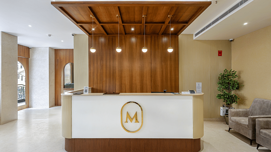 The reception at Monday Premium, Madhapur, featuring a long table, cushions, lights, and a hallway.