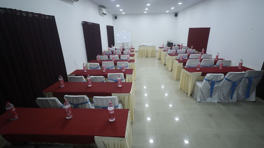 The spacious Emerald Hall at Mountview Resort setup with rows of tables covered with cloth, chairs with covers, and bottled water placed at each seat.