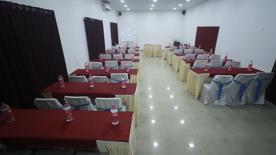 The spacious Emerald Hall at Mountview Resort setup with rows of tables covered with cloth, chairs with covers, and bottled water placed at each seat.