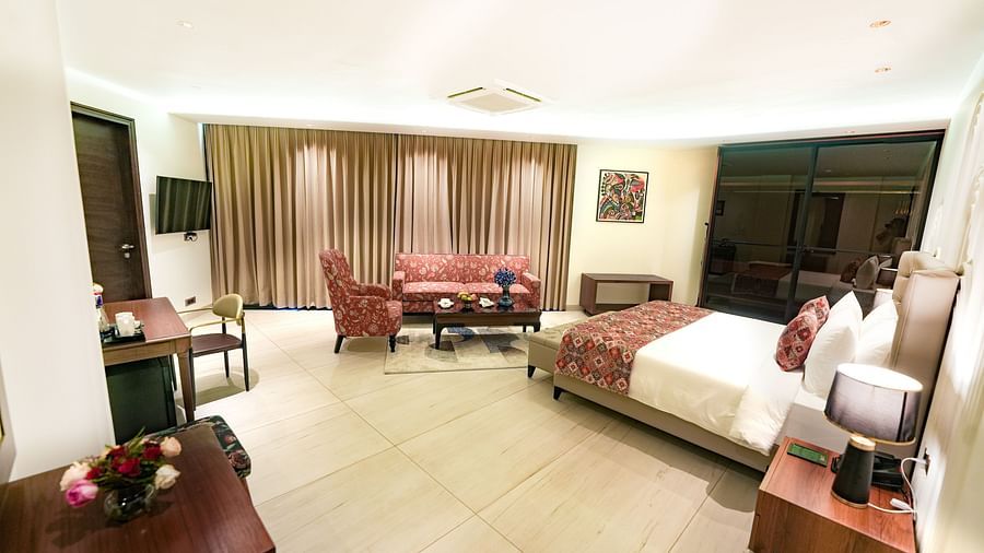 An image showcasing the expansive suite, complete with cosy furniture and a plush queen size bed - NAMAMI BY ZENQ BANKHANDI