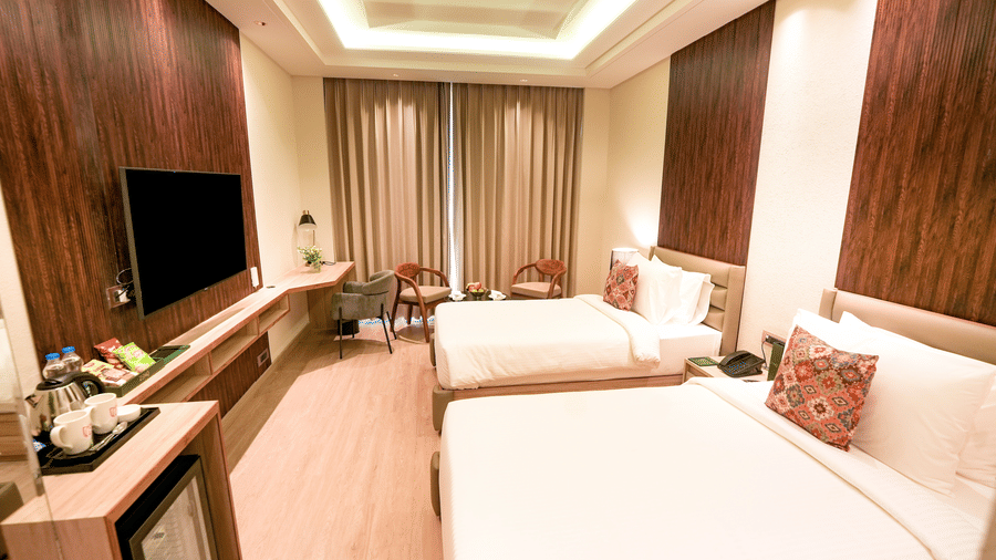 The Superior Temple View room in Bankhandi with twin beds, a minibar, a wall-mounted television and chairs - NAMAMI BY ZENQ BANKHANDI