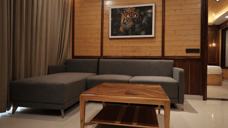 Presidential suite living area with a modern sofa, wooden coffee table, warm lighting, and elegant contemporary decor.