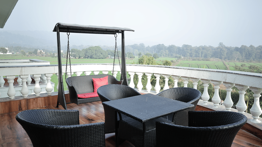 Verdant Plunge Villa balcony seating area overlooking lush greenery and tranquil outdoor surroundings.