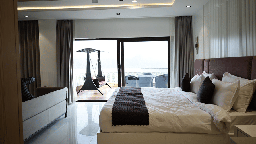 Verdant Plunge Villa bedroom with king-size bed, modern décor, and balcony view allowing natural daylight.