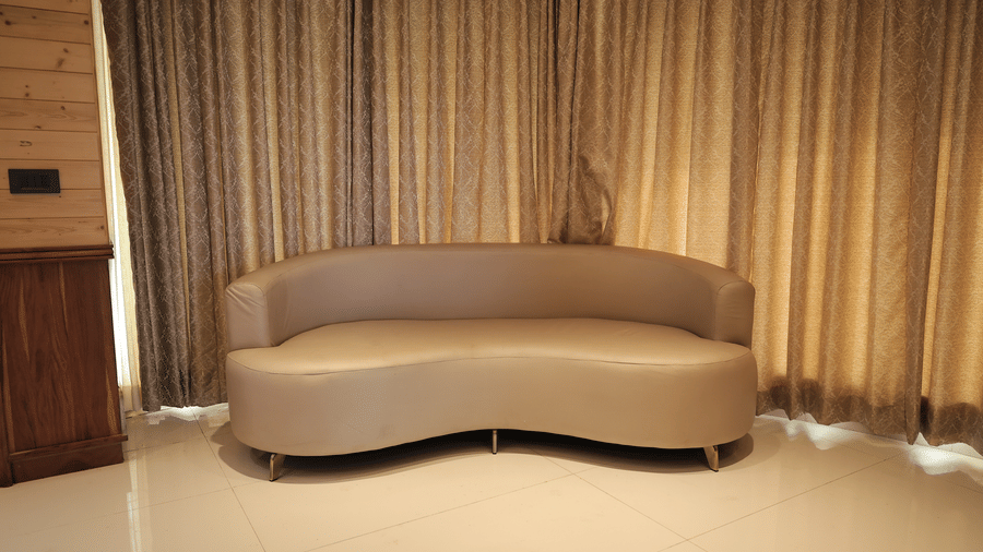 Sofa seating area in the Bliss Bloom Suite with soft lighting and elegant curtains.