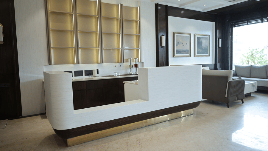 Stylish lobby refreshment counter with illuminated shelving, marble counter surface, and modern interior design.