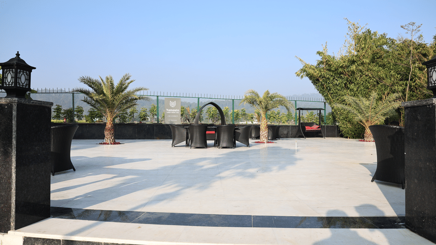 Tiled outdoor patio featuring a decorative palm trees, and comfortable garden seating.