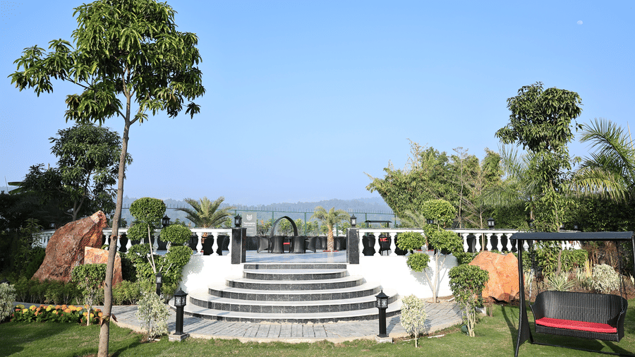 Elegant stone steps leading to an elevated outdoor terrace with garden swings and manicured landscaping.
