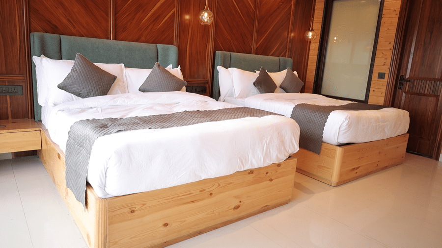 A bedroom with twin beds and wardrobe on the corner.