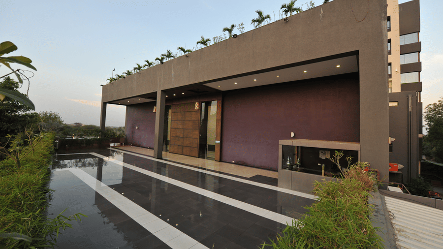 Exterior of a modern building with a sleek, minimalist design at Narayani Heights Hotel & Resorts, Ahmedabad.