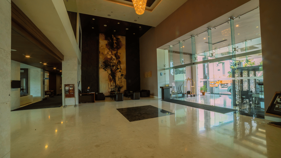 Modern hotel lobby with a high ceiling, a chandelier and glass entrance – Narayani Heights Hotel & Resorts