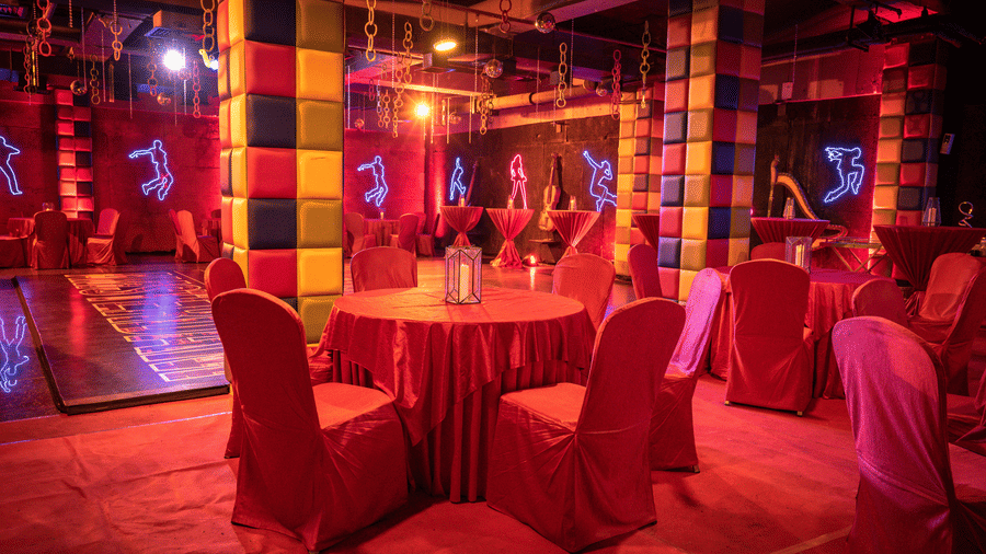 Discotheque setup with red lighting and round table arrangements – Narayani Heights Hotel & Resorts