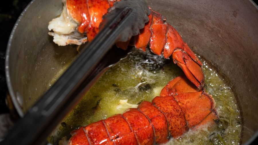 Lobster tails being seared in a pan with butter as part of a seafood dish prepared at the Narrow Gauge Inn kitchen.