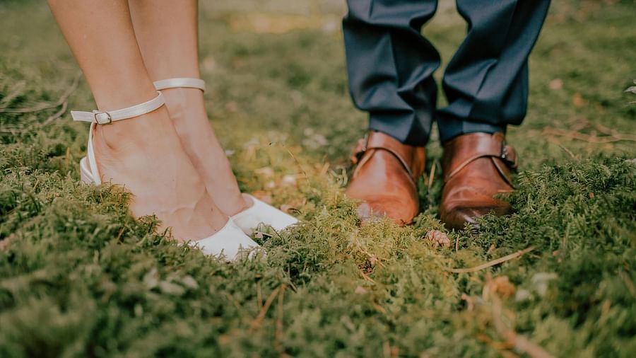 A view of feet of a couple getting married in the wedding attires - Narrow Gauge Inn - A Serenite Hotel Near Fish Camp.