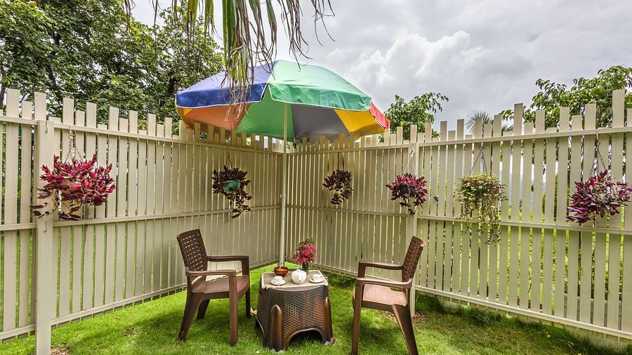 two chairs and a small table in between with a canopy above in a garden area - neer ganga resorts