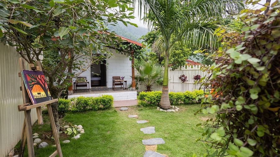 a stone pathway leading to a room on the grass - neer ganga resorts
