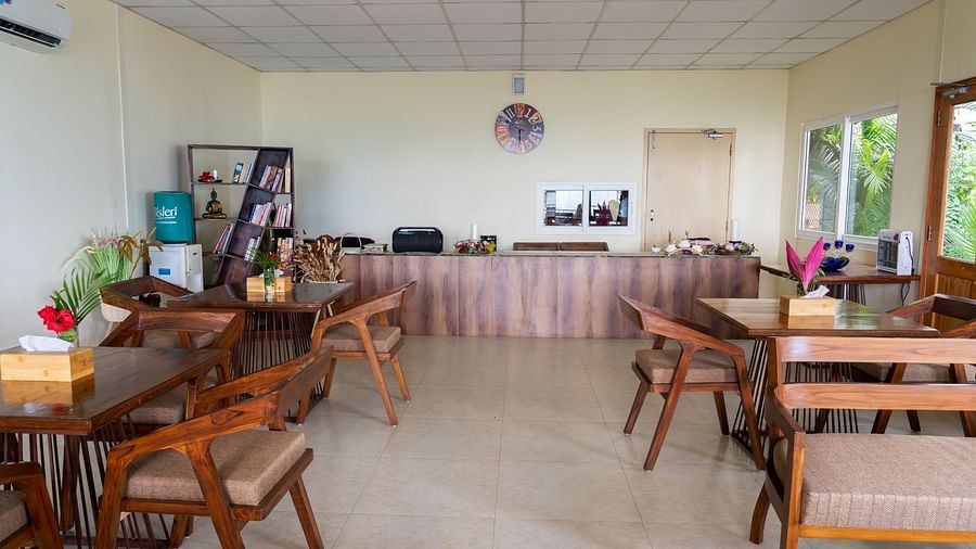 a restaurant with tables and chairs and a buffet table in the back at Neer Ganga Resorts