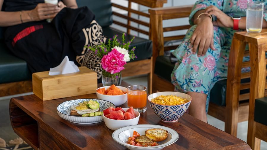 a table set with food with two women sitting on chairs at Neer Ganga Resorts
