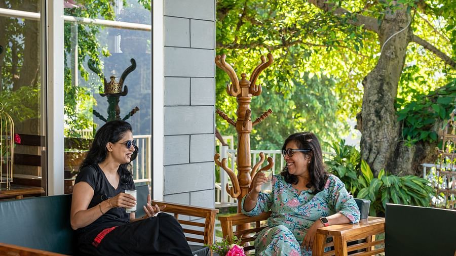 Two women sitting in the open area and enjoying food at Neer Ganga Resorts