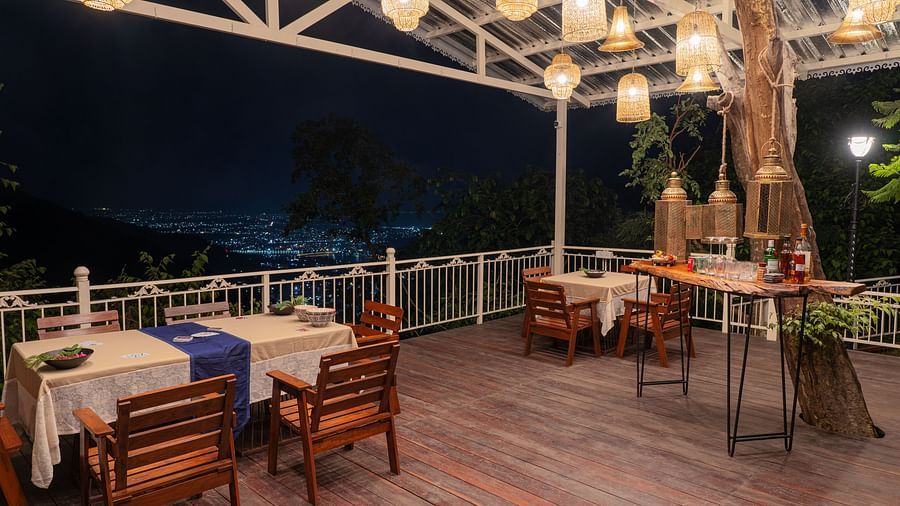 a restaurant with tables and chairs with lighting during evening at Neer Ganga resorts