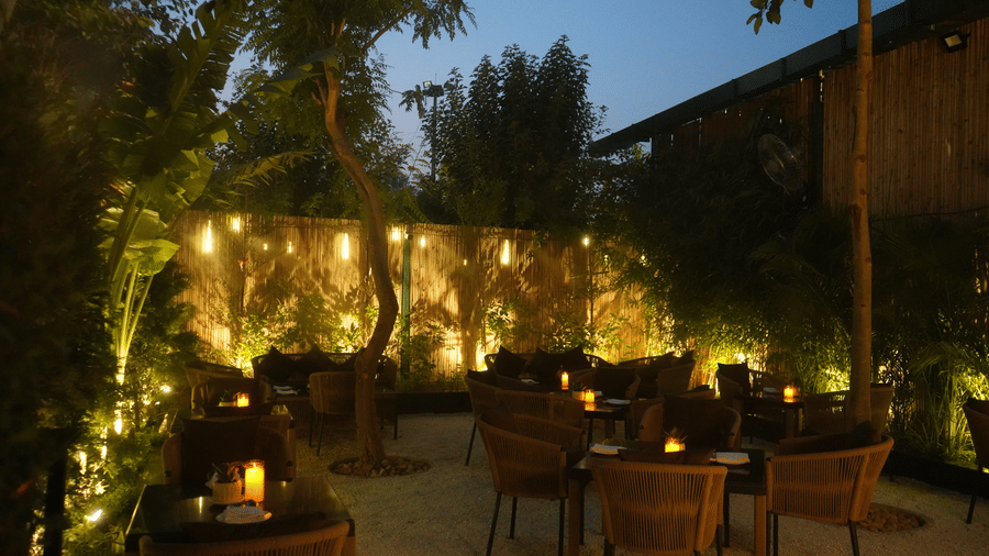 The Hoppe, open air dining option at Nemesia City Center during night time lit with yellow fairy lights.