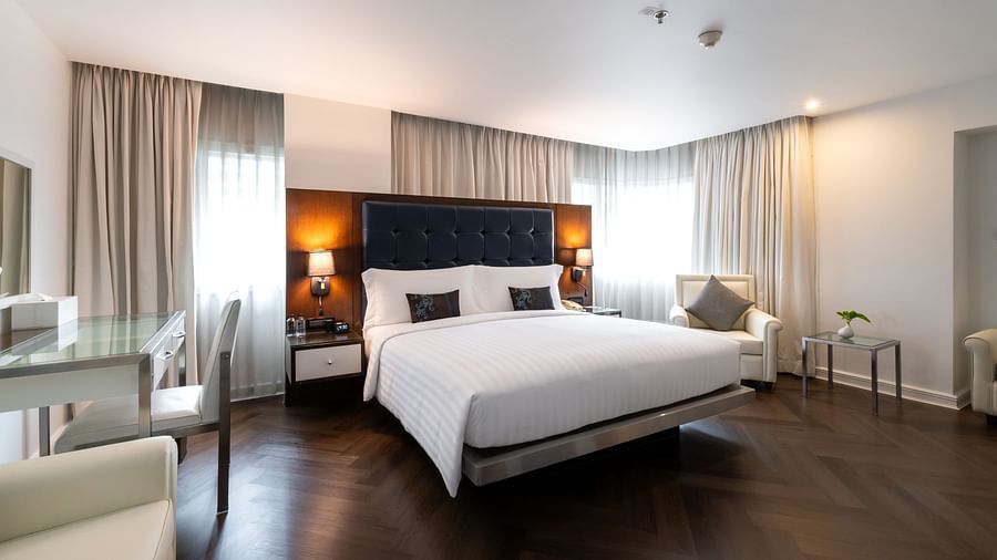 An overview of a double bed with lamps next to the bed inside one of the rooms - Night Hotel Bangkok