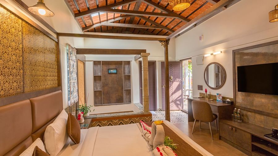 Elegant room with four poster bed and sitting area at Nirantara Resort & Spa