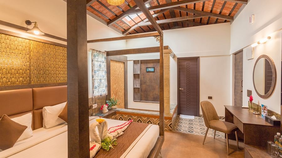 Luxurious bedroom with four poster bed and wooden ceiling at Nirantara Resort & Spa