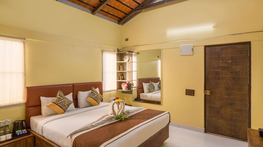 Spacious bedroom with double bed and wooden ceiling – Nirantara Resort & Spa