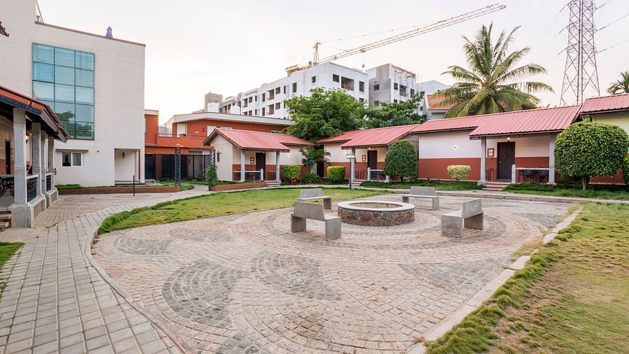 Courtyard area with stone seating and cottage surroundings at Nirantara Resort & Spa