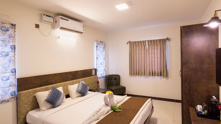 Contemporary bedroom with seating area and air conditioning – Nirantara Resort & Spa