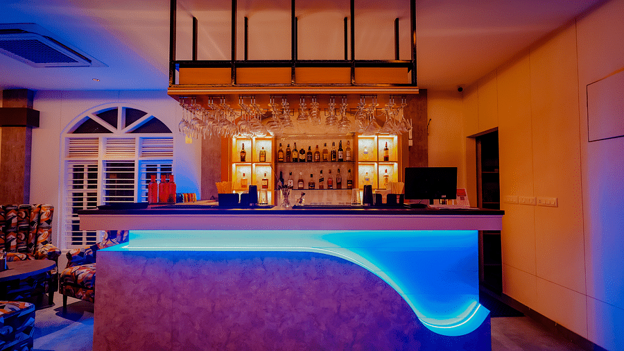The stylish bar area at Nirantara Resort & Spa, featuring modern lighting, comfortable seating, and a wide selection of beverages.