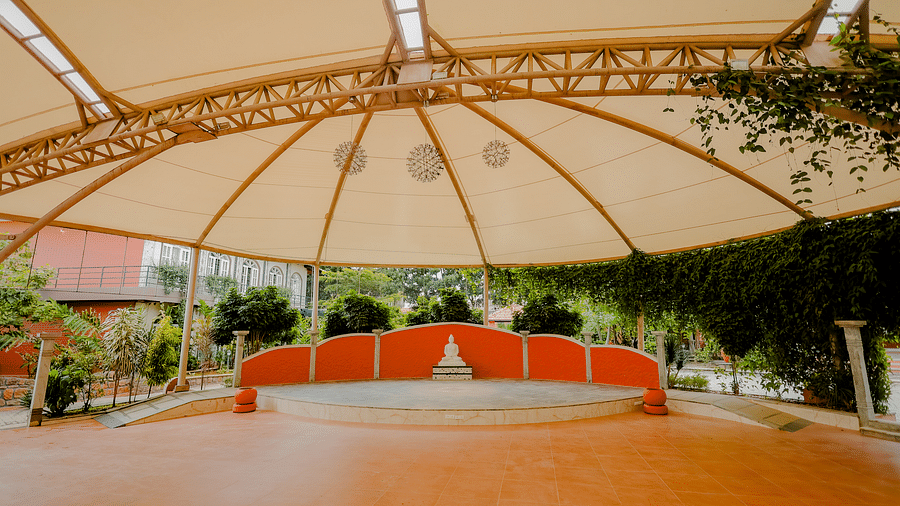 An outdoor event space with a large canopy and a stage at Nirantara Resort & Spa.