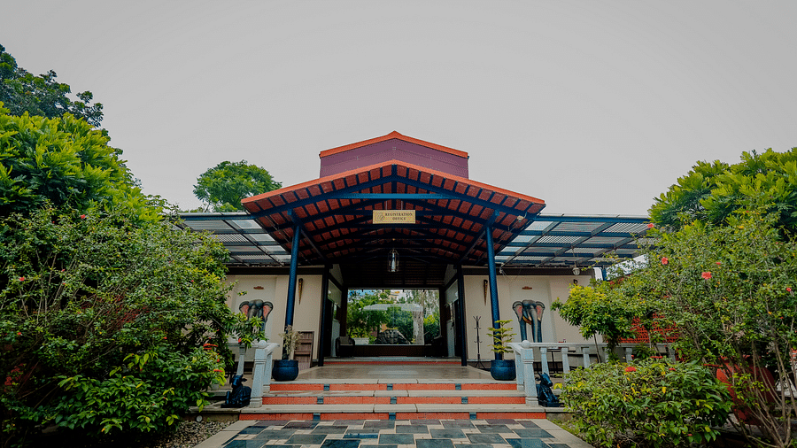 The entrance to a building with a tiled roof and steps leading up, possibly at Nirantara Resort & Spa in Bengaluru.