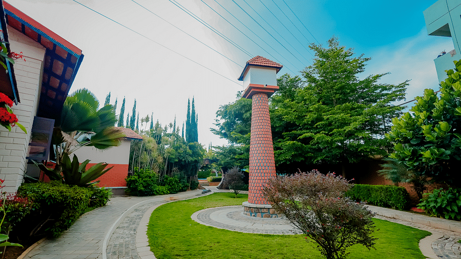 The grounds of Nirantara Resort & Spa with a clock tower, landscaped gardens, and pathways.