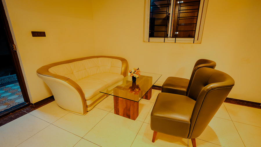 A seating area with a sofa and chair in a room at Nirantara Resort & Spa.