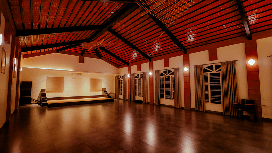 An empty event space or hall with a high ceiling and wooden floor at Nirantara Resort & Spa.